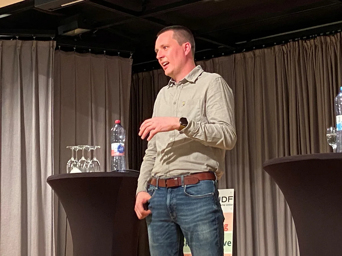 Sebastian Köstli steht auf der Bühne und stellt sich vor.